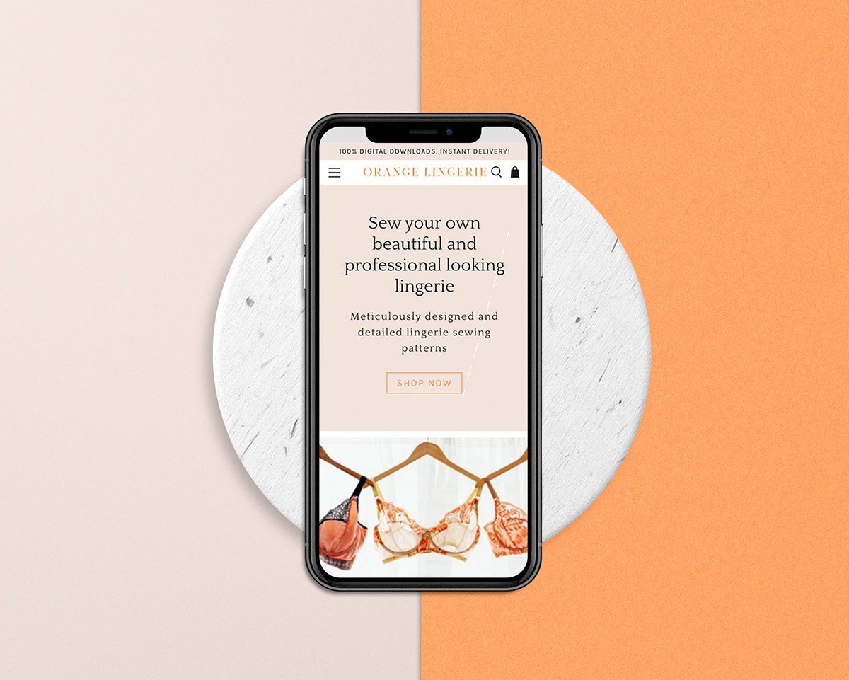 orange lingerie homepage design on an iphone with a circle background