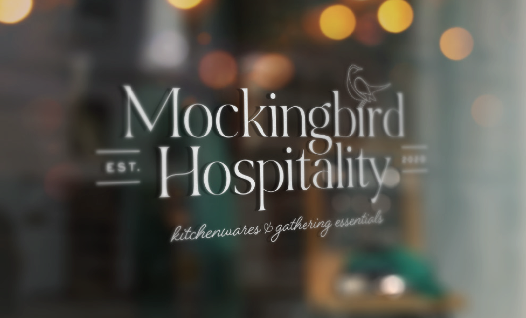 store window mockup of the primary logo of Mockingbird Hospitality